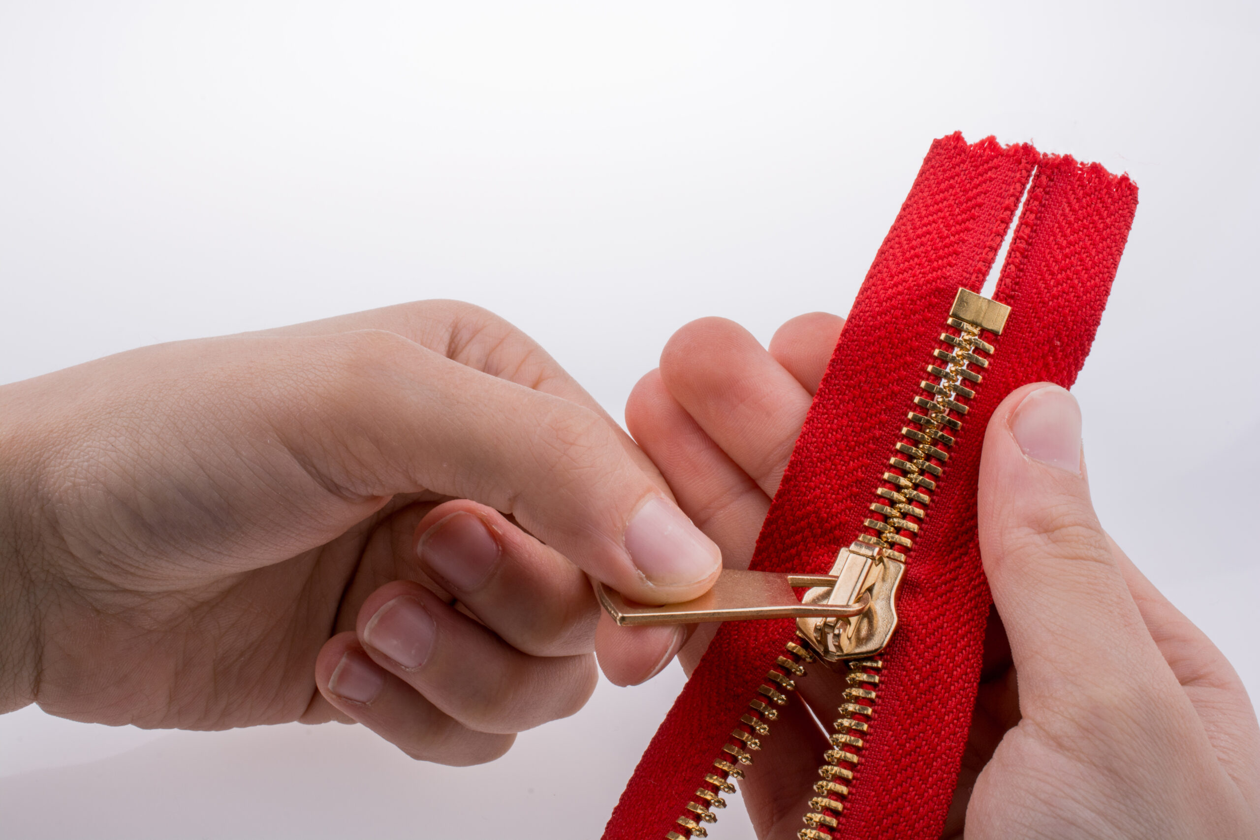 Hand holding color zipper on a white background