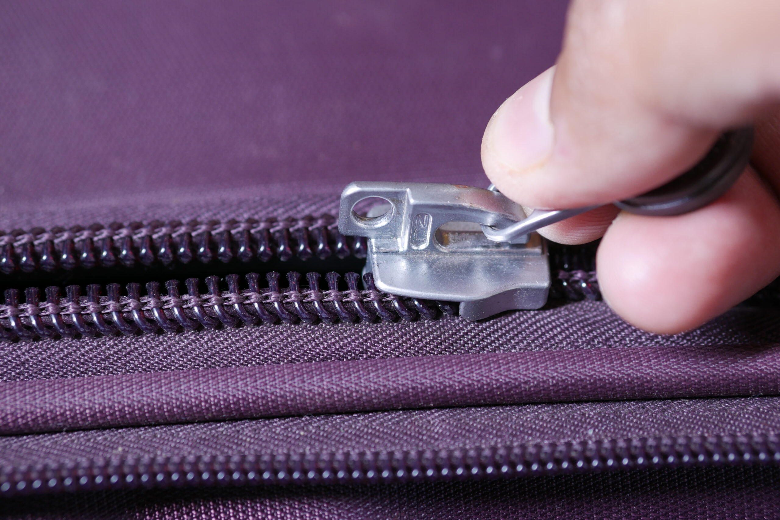 hand in a Zipper on a suitcase close up